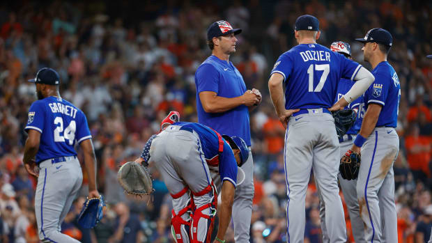 Jul 4, 2022; Houston, Texas, USA; Kansas City Royals manager Mike Matheny (22) holds a ball and relief pitcher Amir Garrett (24) walks off the mound after a pitching change during the eighth inning against the Houston Astros at Minute Maid Park. Mandatory Credit: Troy Taormina-USA TODAY Sports